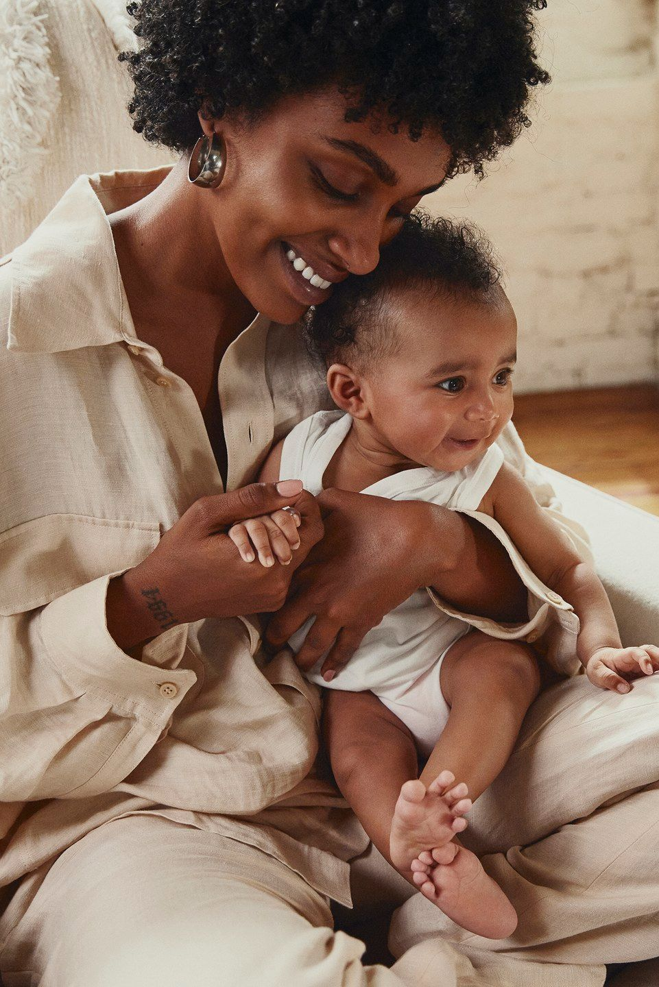 A mother smiling while holding her baby